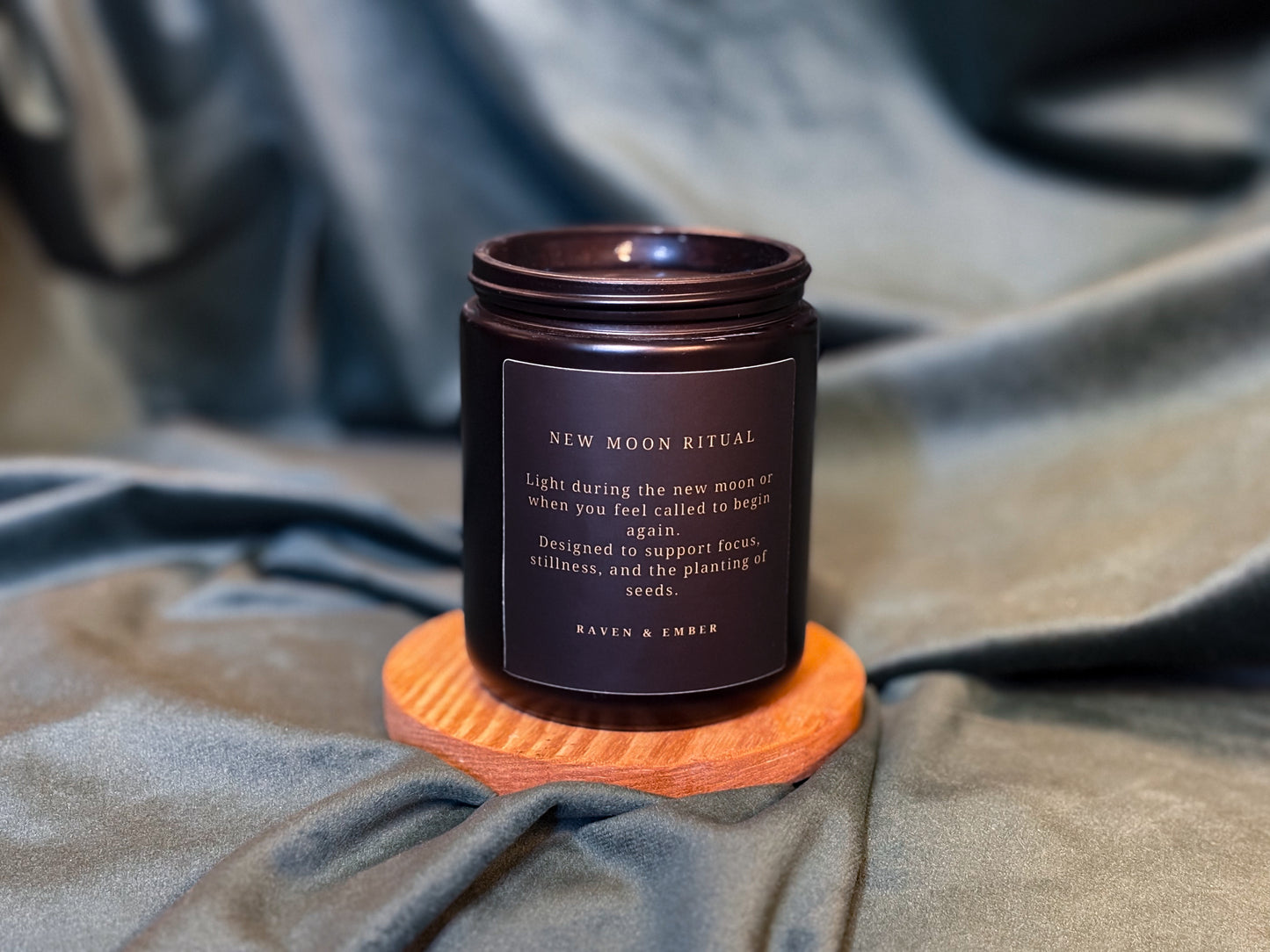 Candle jar labeled 'New Moon Ritual' on a textured surface