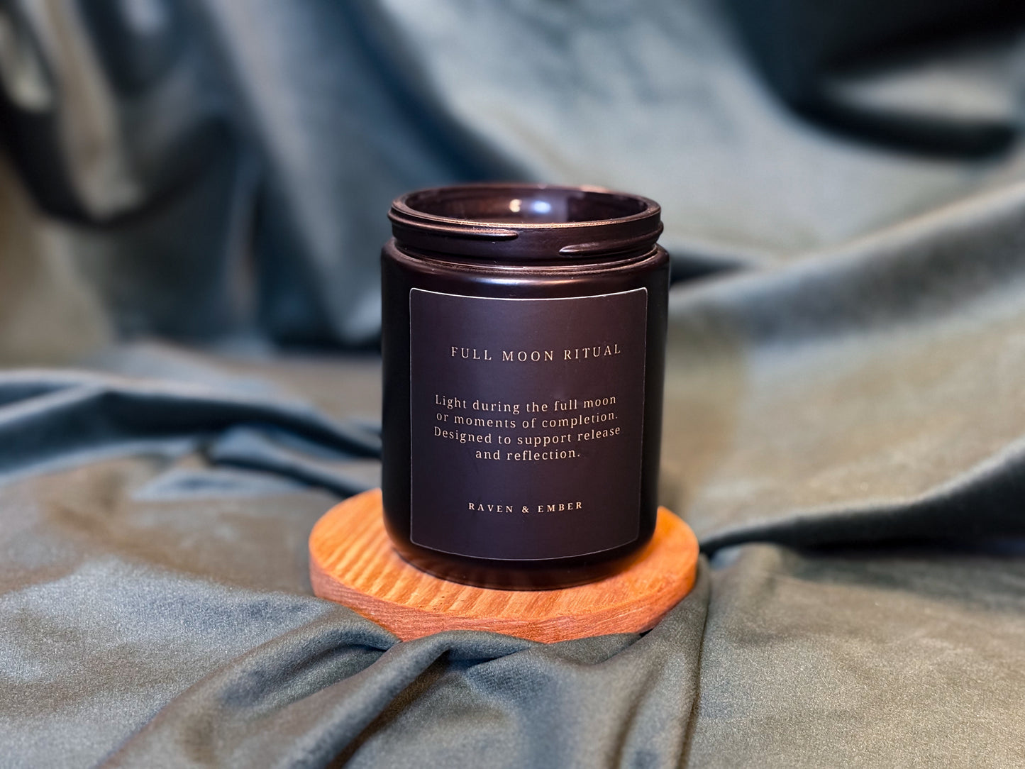 Candle labeled 'Full Moon Ritual' on a textured surface