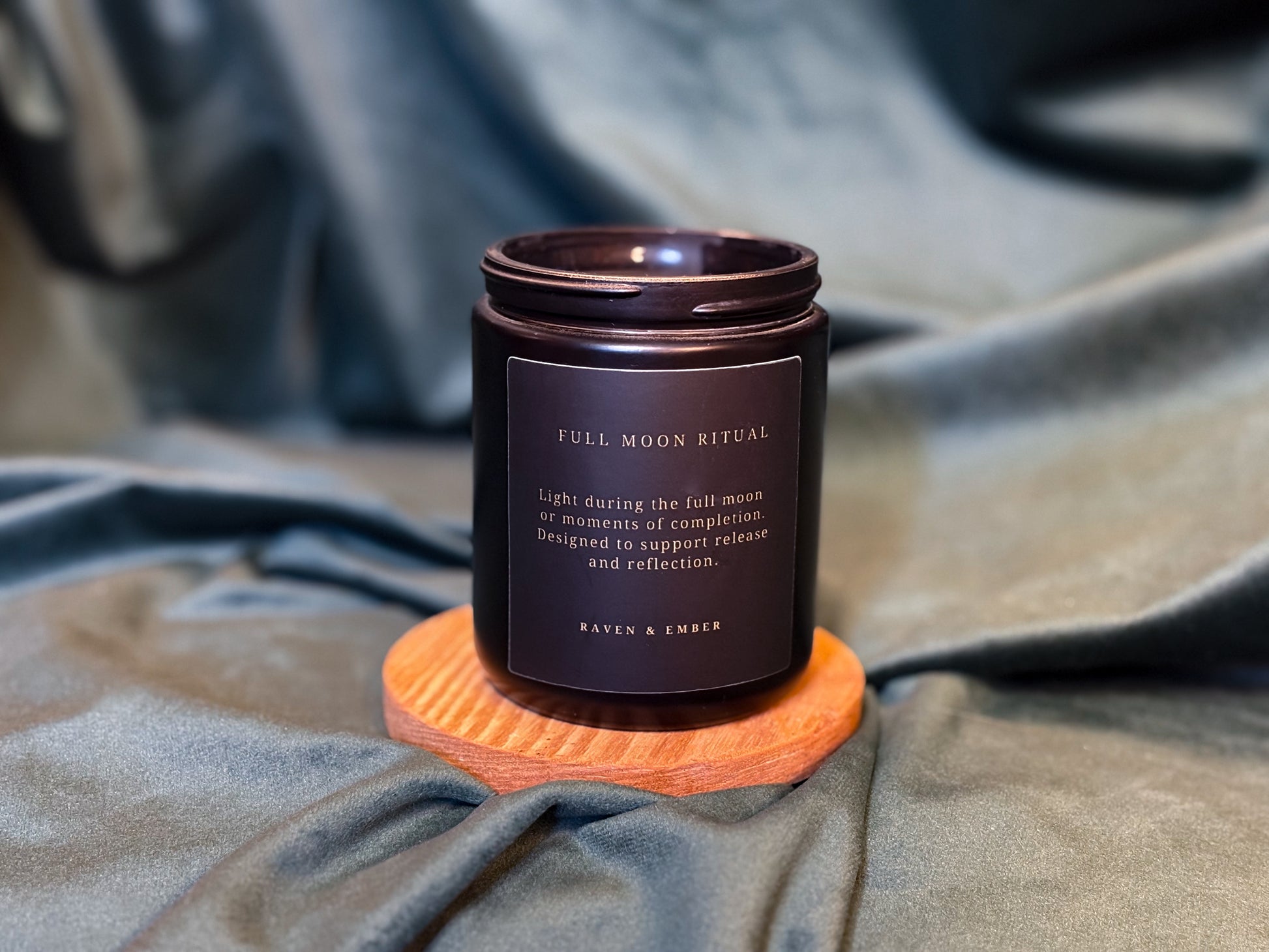 Candle labeled 'Full Moon Ritual' on a textured surface